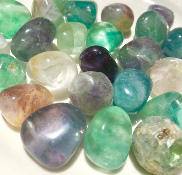 A collection of colorful fluorite tumbled stones.