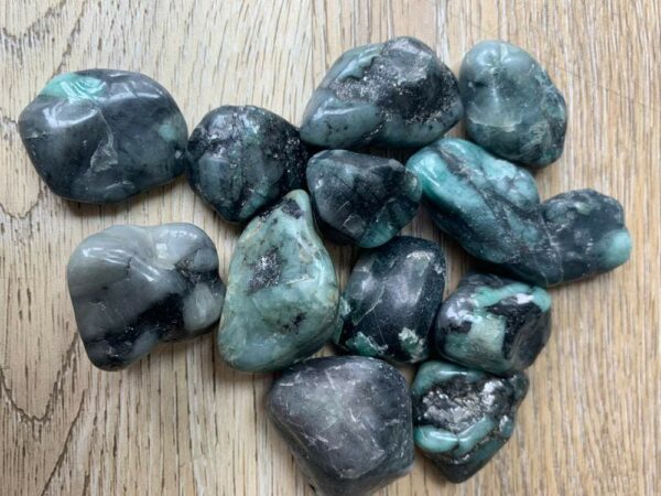 Green and black tumbled emerald stones.