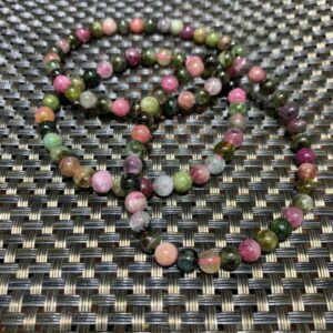 Multicolored gemstone beaded bracelet on black mat.