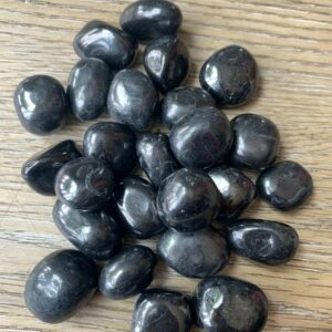 Pile of smooth black tourmaline stones.