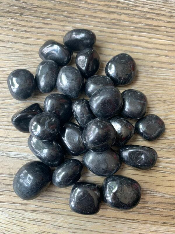 Pile of smooth black tourmaline stones.