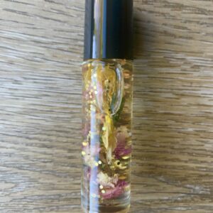 Gold glitter roll-on bottle with flowers.