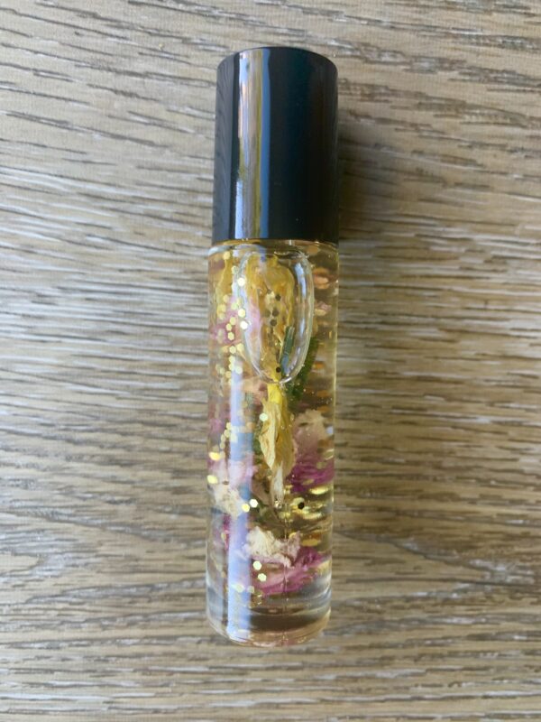 Gold glitter roll-on bottle with flowers.