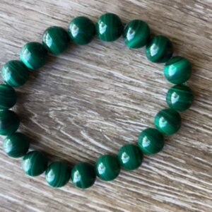 Green malachite bead bracelet on wood.