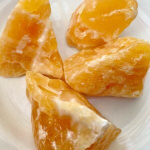 Four orange calcite crystal chunks.