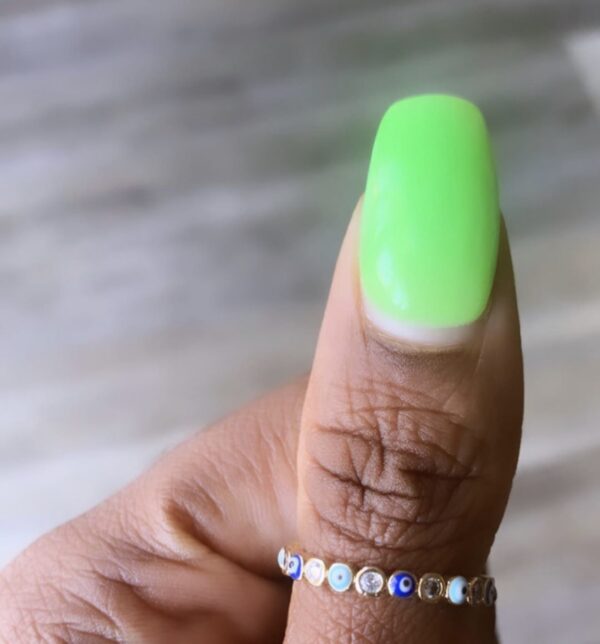 Hand with green nail polish and evil eye ring.