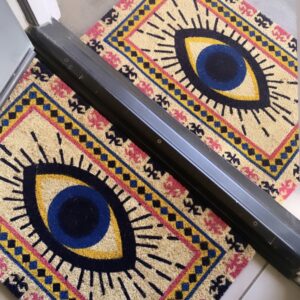 Doormat with colorful evil eye design.