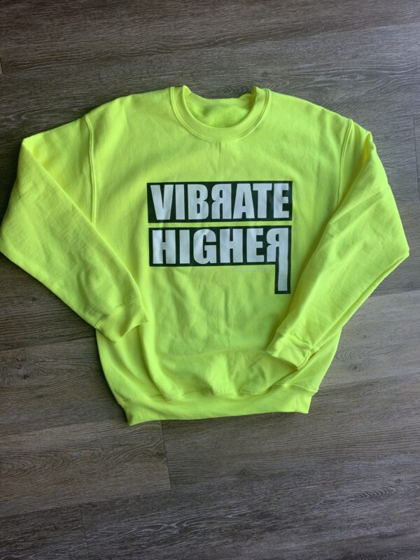 Yellow sweatshirt with "Vibrate Higher" text.