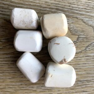 Five white stones on woodgrain background.