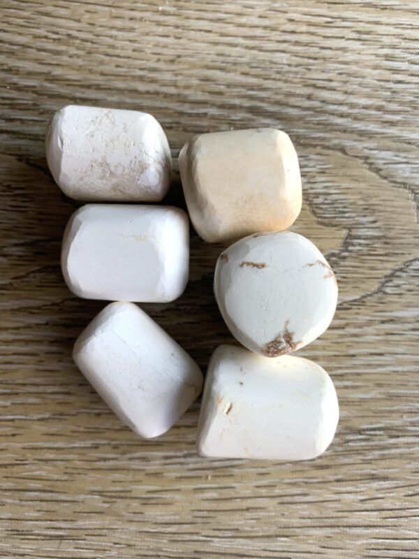 Five white stones on woodgrain background.