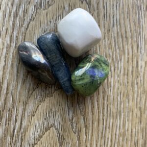 Four colorful stones on wooden surface.