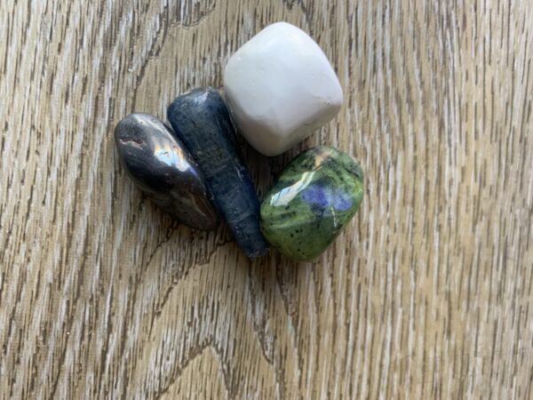 Four colorful stones on wooden surface.