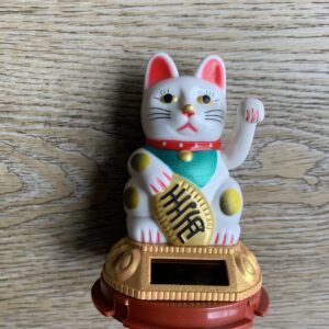 White lucky cat with raised paw.