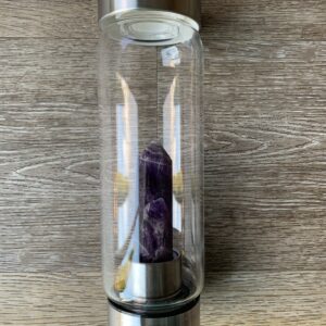 Amethyst crystal water bottle on wood.