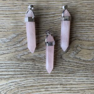 Three pink quartz crystal pendants.