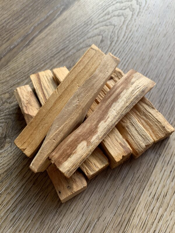 Stack of light brown palo santo sticks.