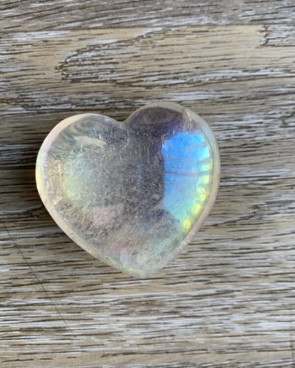 Clear heart-shaped crystal on wood grain.