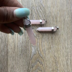 Three pink crystal pendants on wood.