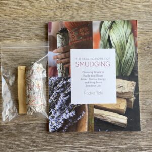 Smudging book with sage and palo santo sticks.