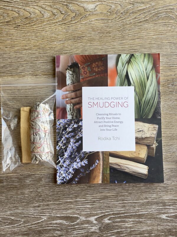 Smudging book with sage and palo santo sticks.