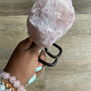 Hand holding a large pink crystal.