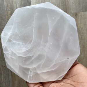 White selenite crystal plate in hand.