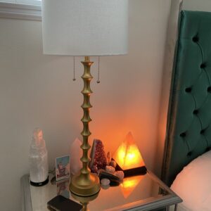 Gold lamp on a mirrored nightstand.