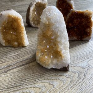 Four citrine crystal clusters on wood.