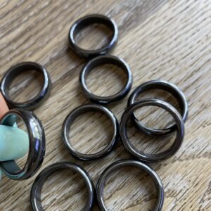 Black hematite rings on wood background.