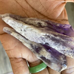 Purple amethyst crystals in hand.