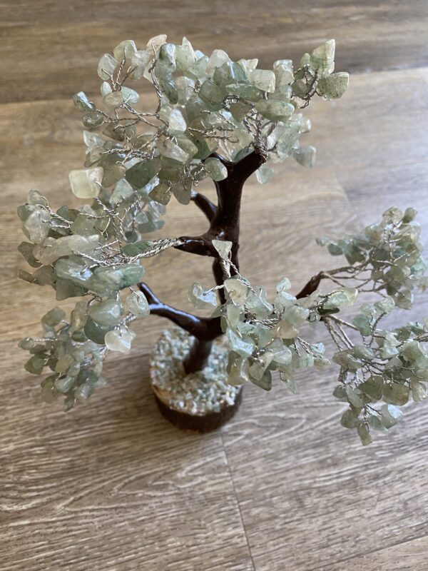 Green crystal wire wrapped tree on wood.