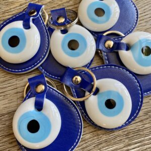 Blue evil eye keychains on wood table.