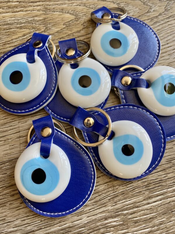 Blue evil eye keychains on wood table.