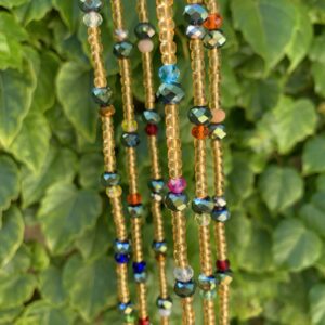 Colorful beaded necklace with green foliage background.