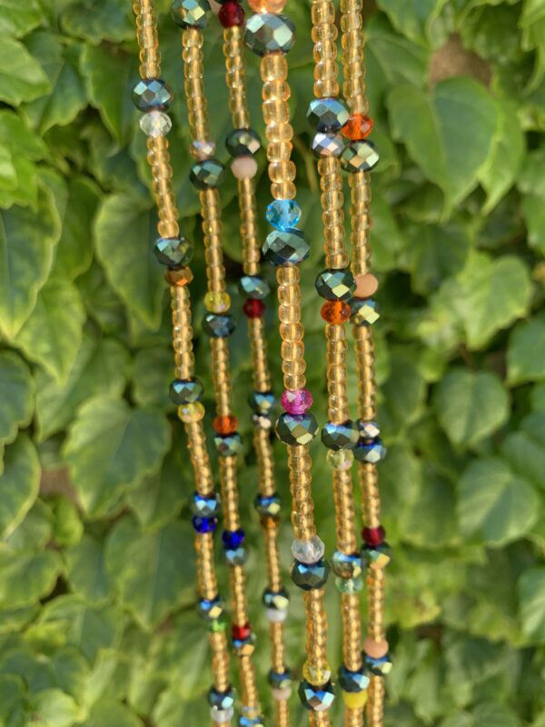 Colorful beaded necklace with green foliage background.