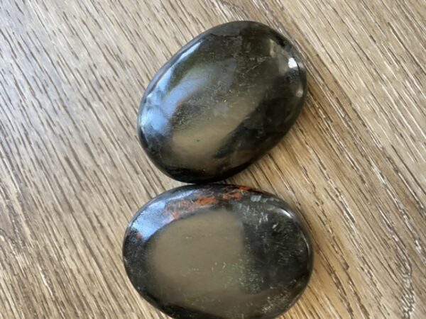 Two smooth black and red stones.