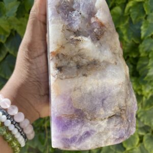 Amethyst crystal in hand, close-up.