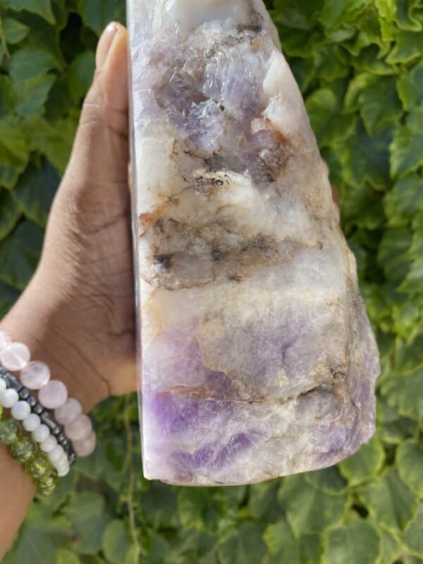 Amethyst crystal in hand, close-up.