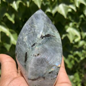 Grey labradorite crystal in hand.