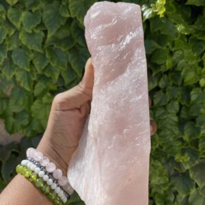 Large pink rose quartz crystal in hand.