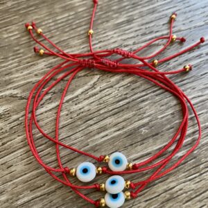 Red string bracelets with blue evil eyes.