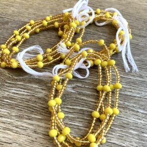 Yellow beaded waist beads with white tassels.