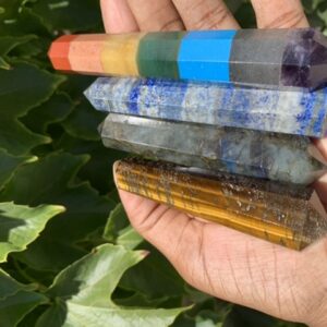 Five colorful crystal wands in hand.