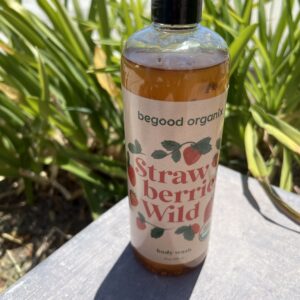 A bottle of strawberry berry wild body wash sitting on top of a table.