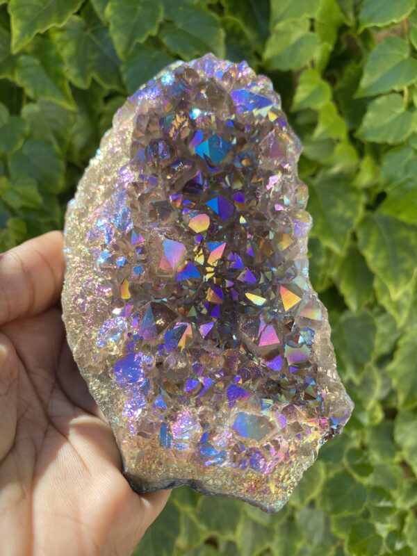 Hand holding a large iridescent crystal.