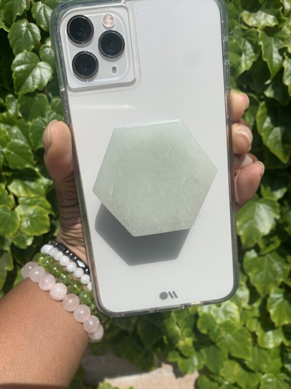 A white phone case with a green stone grip.