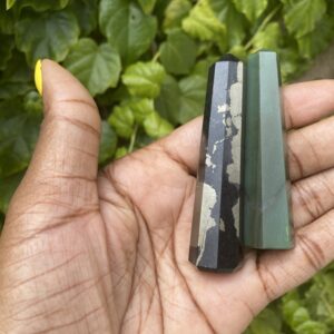 Black and green crystal points in hand.