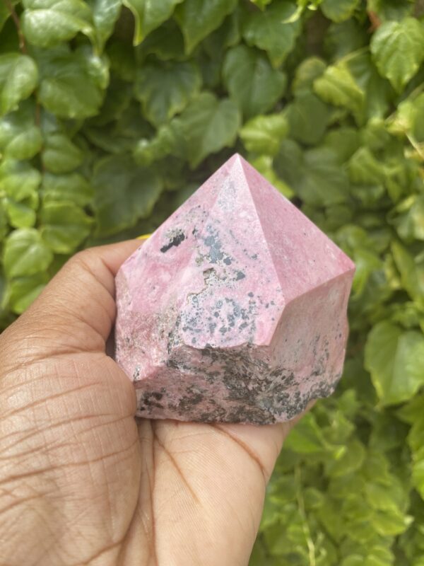 Pink Rhodonite crystal in hand.