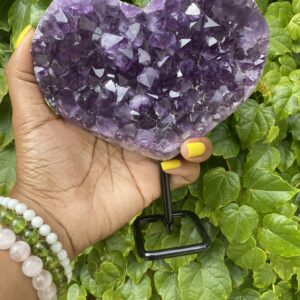 Purple amethyst heart crystal on stand.