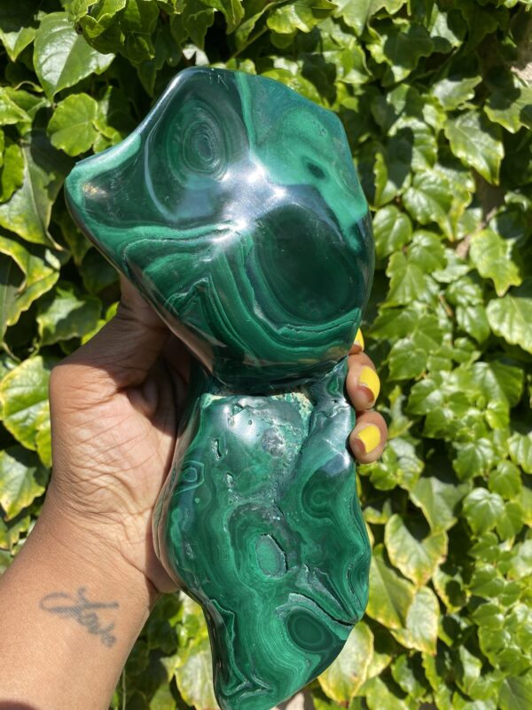 Green malachite stone held in hand.